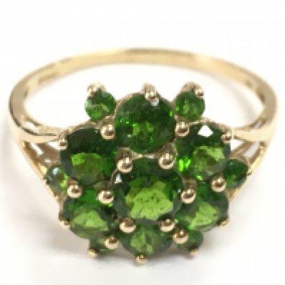 A 9 carat gold ring set with green gemstones , 2.6g total weight . Postage category A
