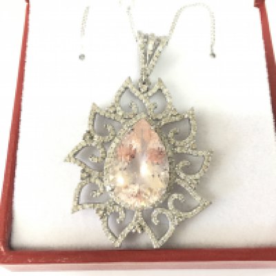 A silver pendant set with pear shaped morganite and diamonds in an ornate setting on a silver chain. Morganite 8.80ct and 1.51ct diamonds. Postage B