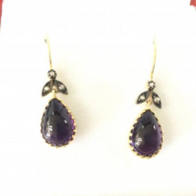 A pair of 9ct yellow gold and silver drop earrings set with oval cabochon amethyst with rose cut diamond set bales. Amethyst 2.80ct approx and 0.06ct diamond.