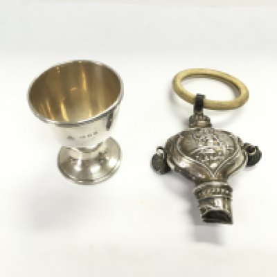 A London hallmarked silver egg cup from circa 1950 weighing 28.81g and a Birmingham hallmarked silver 1926 Rattle 44.25g