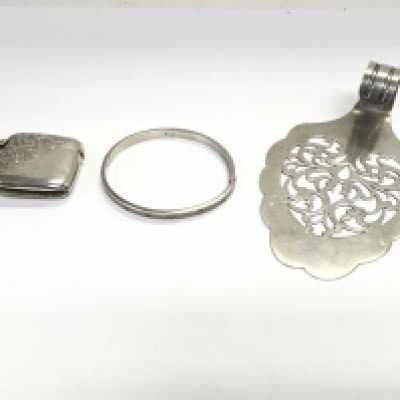A silver bangle and vesta 43.57g and a silver plated cake slice. Postage B