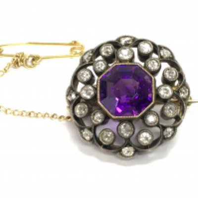 A gold and silver diamond and amethyst set brooch. Diameter approximately 20mm and 6g Postage B
