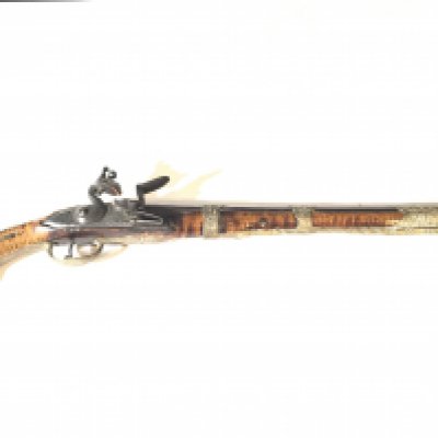 A late 18th Century Spanish flint lock pistol with a figured walnut stock with applied silver and brass ornamentation and patterned barrel action functional.