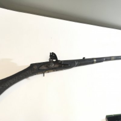 A 19th century Indian or North West Frontier Jezail flintlock rifle with a carved stock wired barrel.