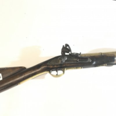An 18th Century English brass barrel Blunderbuss flintlock most likely a coachmen&rsquo;s protection arm. With a wide opening flared barrel with turned end and some ornamentation brass fittings the action stamped with Royal Crown GR.