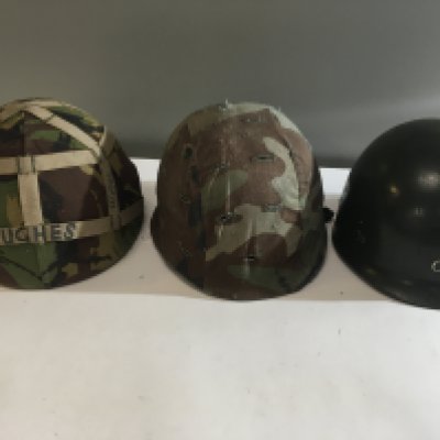 A British 1960 Military helmet with camouflage cover one other conforming helmet and a plastic helmet (3)