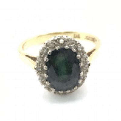An 18ct gold green sapphire a diamond chip ring. Size N 1/2 and 4.63g Postage A