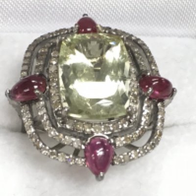 Large cluster dress ring in white metal set with central green beryl surrounded by pear shaped rubies and R/C diamonds, boxed. Beryl 7.43ct. Rubies 2.10ct. Diamonds 0.85ct. Ring size Approx N/O. Postage category A.