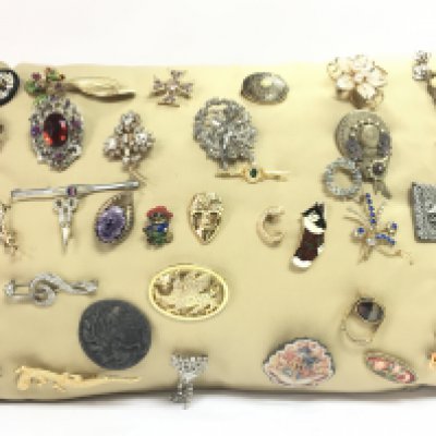 A cushion of vintage brooches. Postage category C