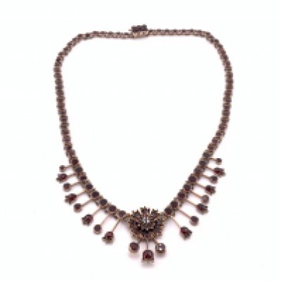 An Edwardian garnet necklace with gold coloured backing, (A)