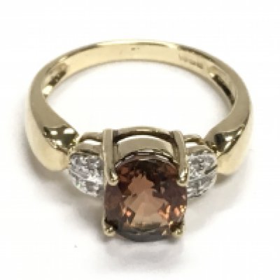 9ct yellow gold ring set with an oval orange tourmaline and diamonds. Tourmaline 1.20ct Approx. Diamonds 0.06ct Approx. Ring size Approx N. Postage category A.