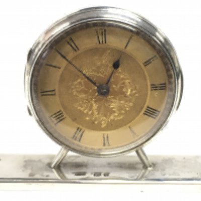 A hallmarked silver dressing table clock. 7cm wide. This lot cannot be posted
