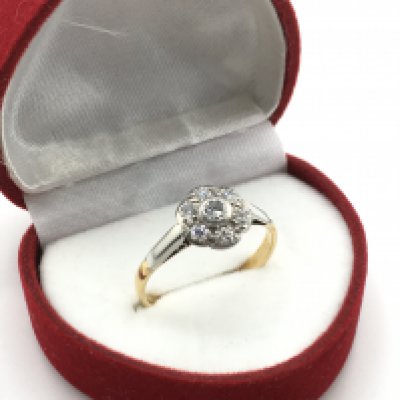An 18 carat yellow and white gold Daisy cluster ring set with diamonds, size R, 2.7g. Postage category a