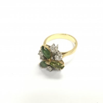 An 18ct gold art deco floral styled ring set with diamonds and green stones. Approx 7.23 grams, size N.
