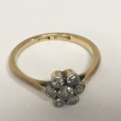 An 18carat gold ring set with a pattern of old cut diamonds one central stone flanked by six ring size M. Weight 3g