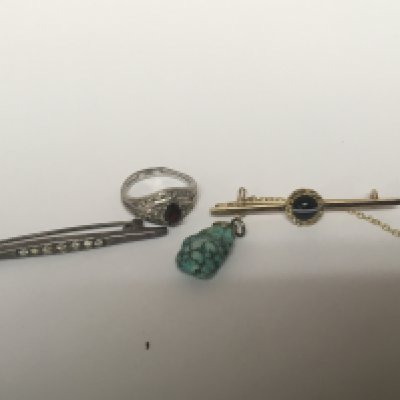 An unmarked gold bar brooch set with a striped polished cabochon stone and chip diamonds. a silver ring small pendent and bar brooch.