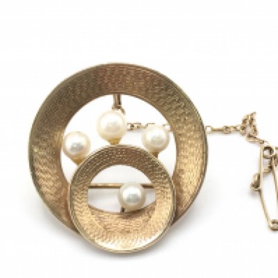 A 9ct gold brooch set with pearls. 8g. Postage B