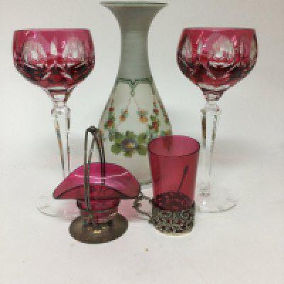 A collection of glass ware including two wine glasses a vase glass beaker with silver rim and a small Cranberry basket .