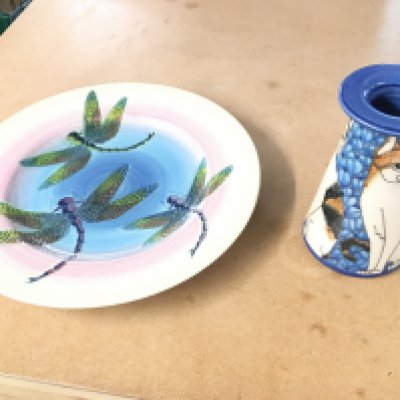 A Dennis China works cat vase by Sally Tuffin along with a Dragon fly plate also by Sally Tuffin Both in good condition with no obvious damage.