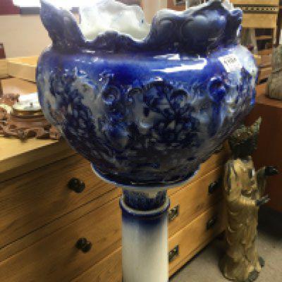 A late Victorian flow blue ceramic jardiniere with a shaped edge on a similar blue ceramic column.