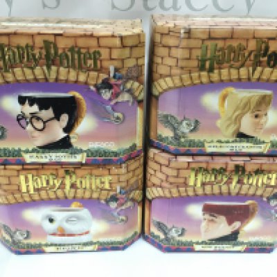 A collection of four boxed Harry Potter mugs by Enesco including Harry Hermione Ron and Hedwig