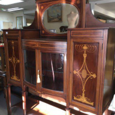A Edwardian inlaid mahogany display cabinet the rasied mirror back above a pair of glazzed doors flanked by cupboards on square tappering legs . 150 cm x 200 cm .