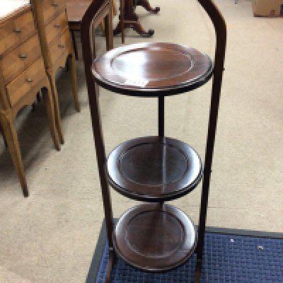 An Edwardian mahogany three tier cake stand shaped handle and folding round tiers. NO RESERVE