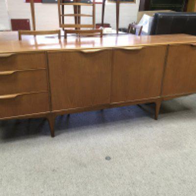 A teak 1970s sideboard fitted with cupboards and doors together with table and six chairs .