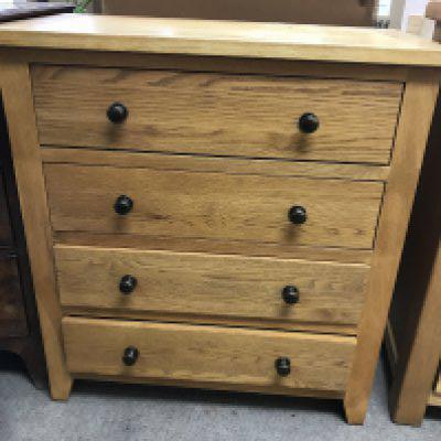 A pine chest the regular top above four drawers .