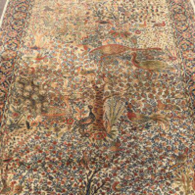A pair of Persian style carpets the centre field with birds and trees with floral borders and a matching rug .