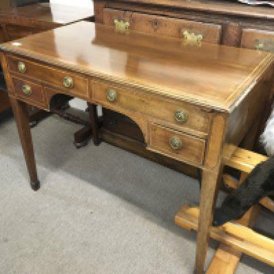 A 19th century mahogany and satinwood cross banded table fitted with four drawers on square tapering legs.