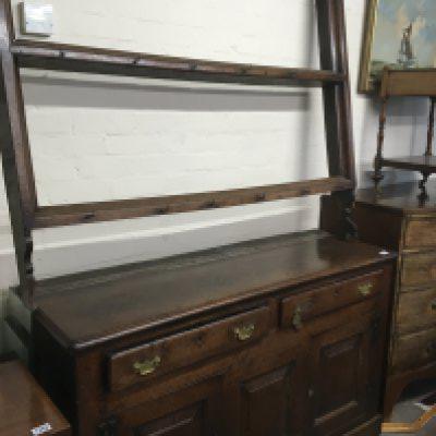 A Vernacular mid 18th century dresser in original condition possible North Wales with a raised open plate rack above two drawers with panel constructed cupboards external hinges. lots of original Caricature in keeping with age. Lenght 145cm