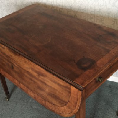 A George III mahogany Pembroke table the top with a wide cross banded edge on square legs.