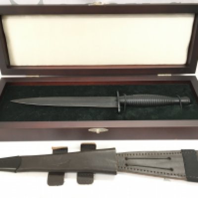 A cased Fairbairn Sykes design fighting knife with a leather scabbard. Knife 29cm long , blade 17cm long.