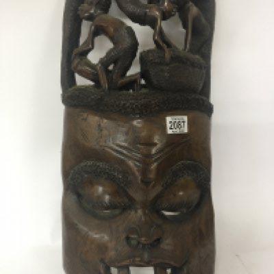 A large carved hardwood African wall mask the top with carved figures height 57cm