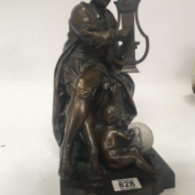 A late 19th century Elkington &Co bronze figure group a Continental seated figure playing a harp with a small putti at foot scribing a tablet. Marks to the underside of the base. Hight 37cm