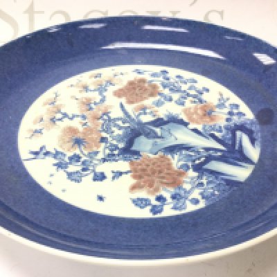 A Chinese blue and white and copper red floral porcelain charger, 30cm wide. This lot cannot be posted