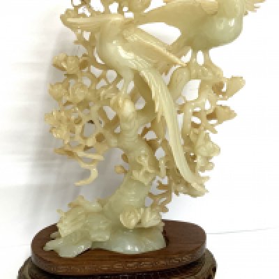 A Chinese bowenite carving of a parrots perched on a tree 20th century, with fitted wood stand, 18cm high (23cm on stand)