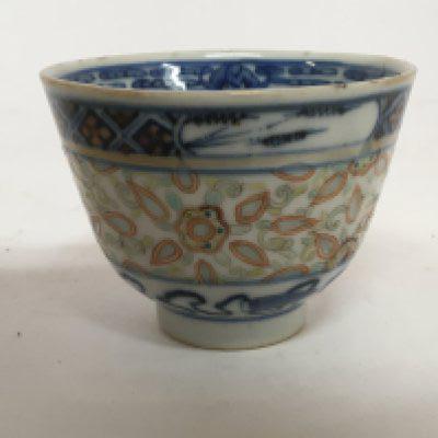 An 18th Century Chinese export porcelain tea bowl with translucent sides patterned and caricature marks to the base.