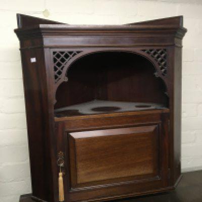 An Edwardian Mahogany corner cabinet with open fretwork corners above a door with key. 68cm. NO RESERVE