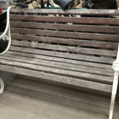 A wrought iron garden bench with scroll supports and wooden slates. Length 125cm long