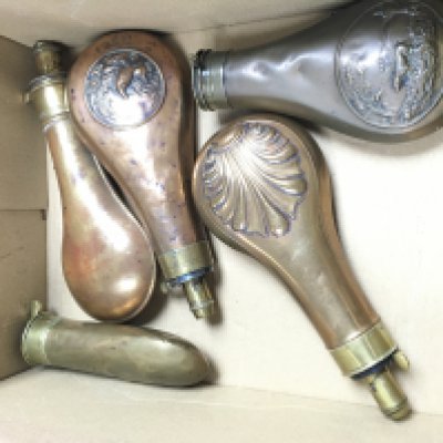 A Collection of vintage powder flasks including examples with embossed designs. Postage cat b