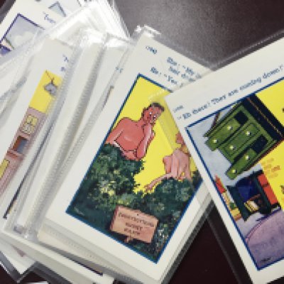 Two boxes containing postcard albums and a large quantity of comical postcards unused and well presented each in a plastic sleeve (2)