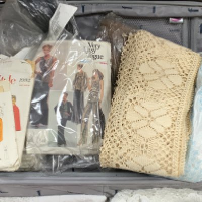 A suitcase full of lace work, edging, beaded dress section, dress designs etc..