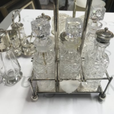 A six bottle cruet frame and two smaller ones along with a silver topped sugar caster. Postage D. NO RESERVE