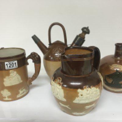 A group of Lambeth and Royal Doulton stoneware ceramics. Including a silver mounted puzzle jug no obvious damage (4)