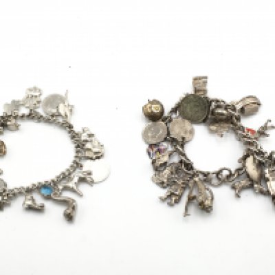 Two vintage silver charm bracelets, postage category A.