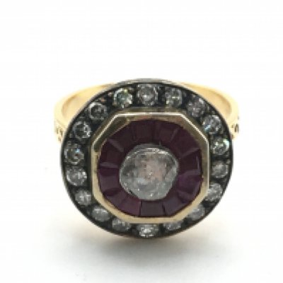 An unmarked hand-made rose gold and silver topped target style cluster ring set with a central rose cut diamond, calibre cut rubies and eight-cut diamonds with patterned shoulders , centre diamond 0.35ct approx. Rubies 0.40ct approx. Eight-cut diamonds 0.40ct approx. Weight 5.9g, ring size O. Postage category A