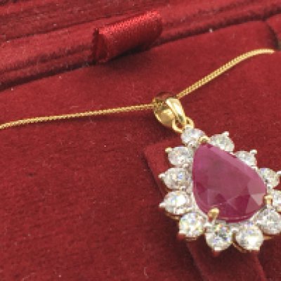 A certificated 18ct yellow and white gold pear shaped ruby and diamond halo necklace with 18ct yellow gold chain, boxed. Ruby 2.30ct. RBC diamonds 1.10ct. Cert no WGI9634150589. Total weight 3.7g. Postage category a