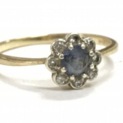 A 9 carat gold ring set with a blue sapphire stone and surrounding small diamonds, 2.1g. Postage category A